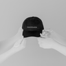 Hand holding House of Exploration Dad Hat