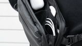 Person wearing the medium black Tech Bag as a crossbody bag, bag open packed out
